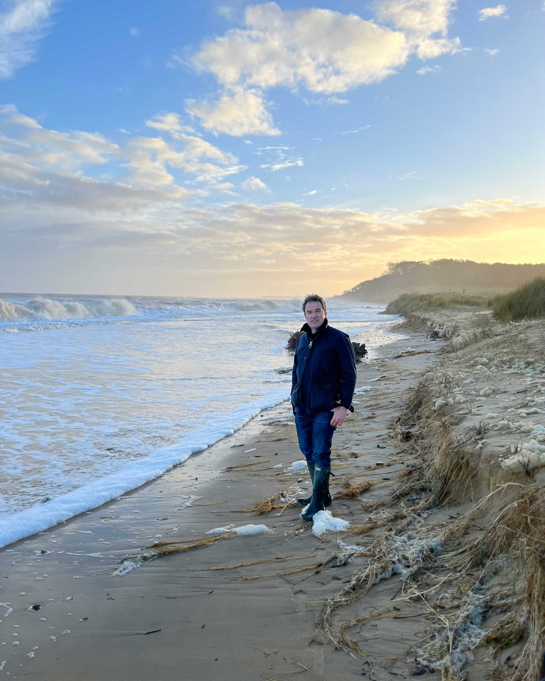A person standing on the shore at dunwich beach 