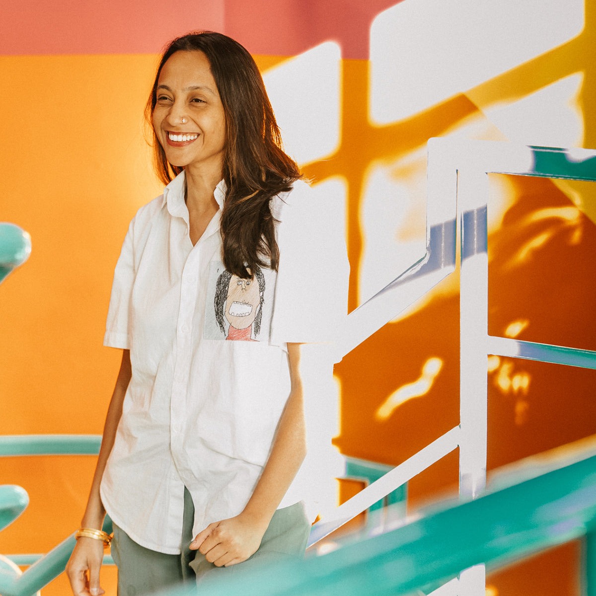 Spandana gopal smiling in front of a colourful background