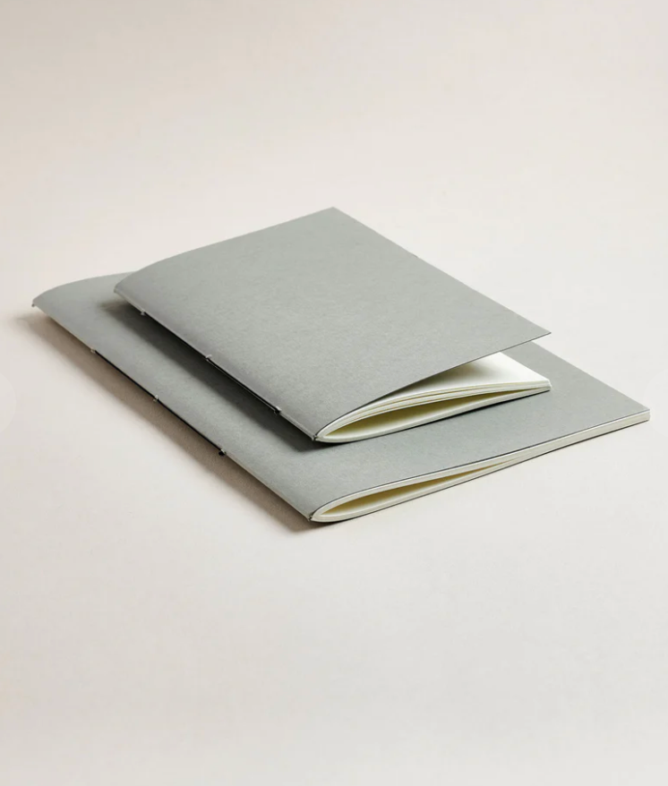 Two light gray notebooks on a white background